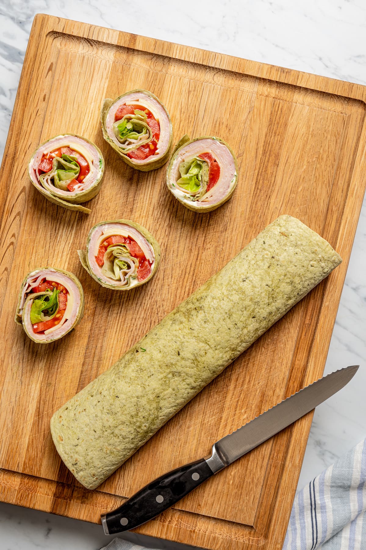 Slicing a wrap into pinwheel sandwiches.