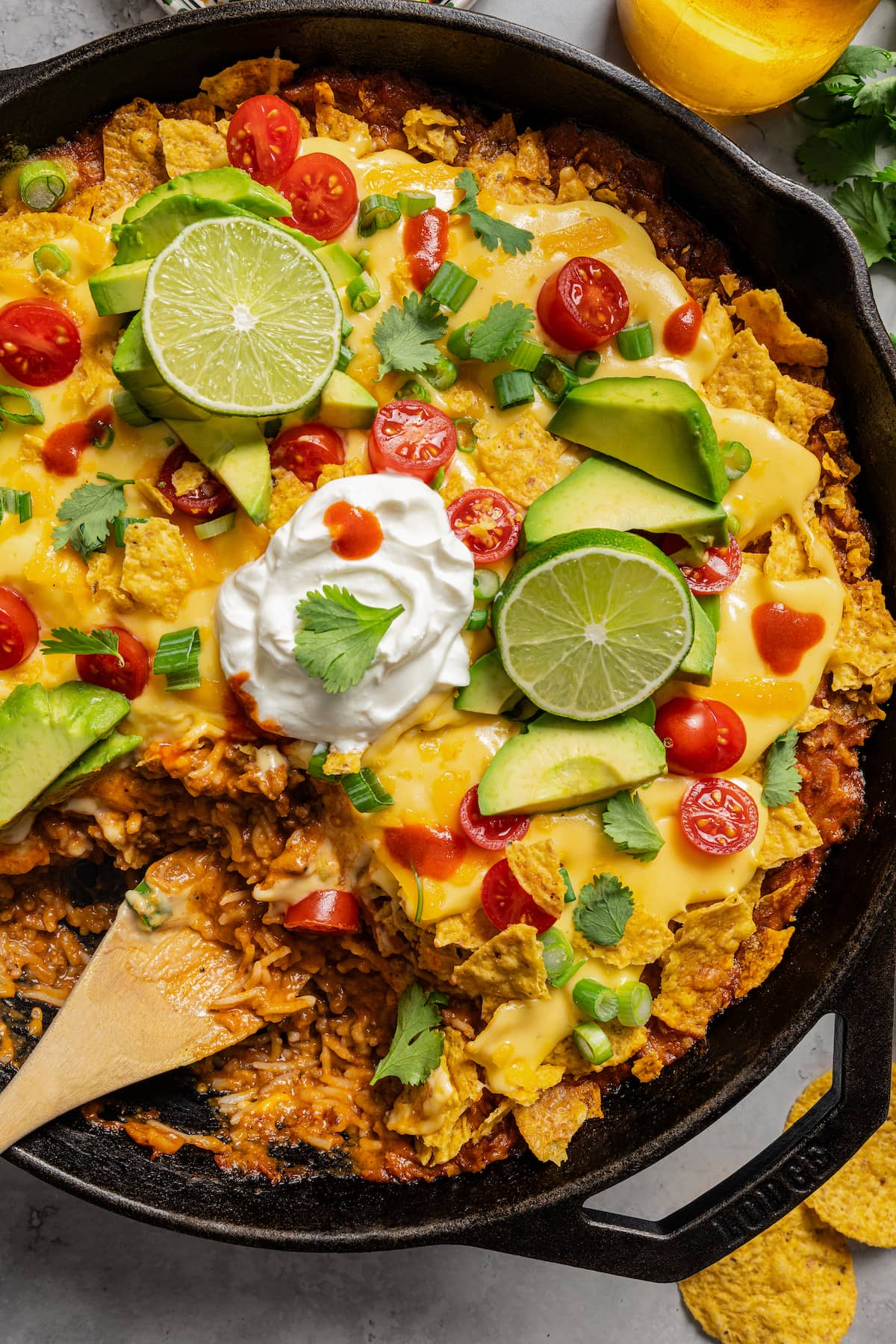 Taco casserole in a skillet with a scoop taken out of it.