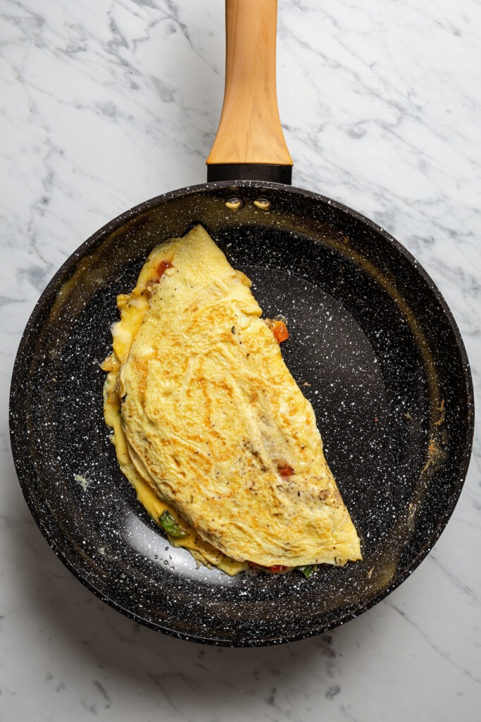 A Western omelette in the pan after being flipped.