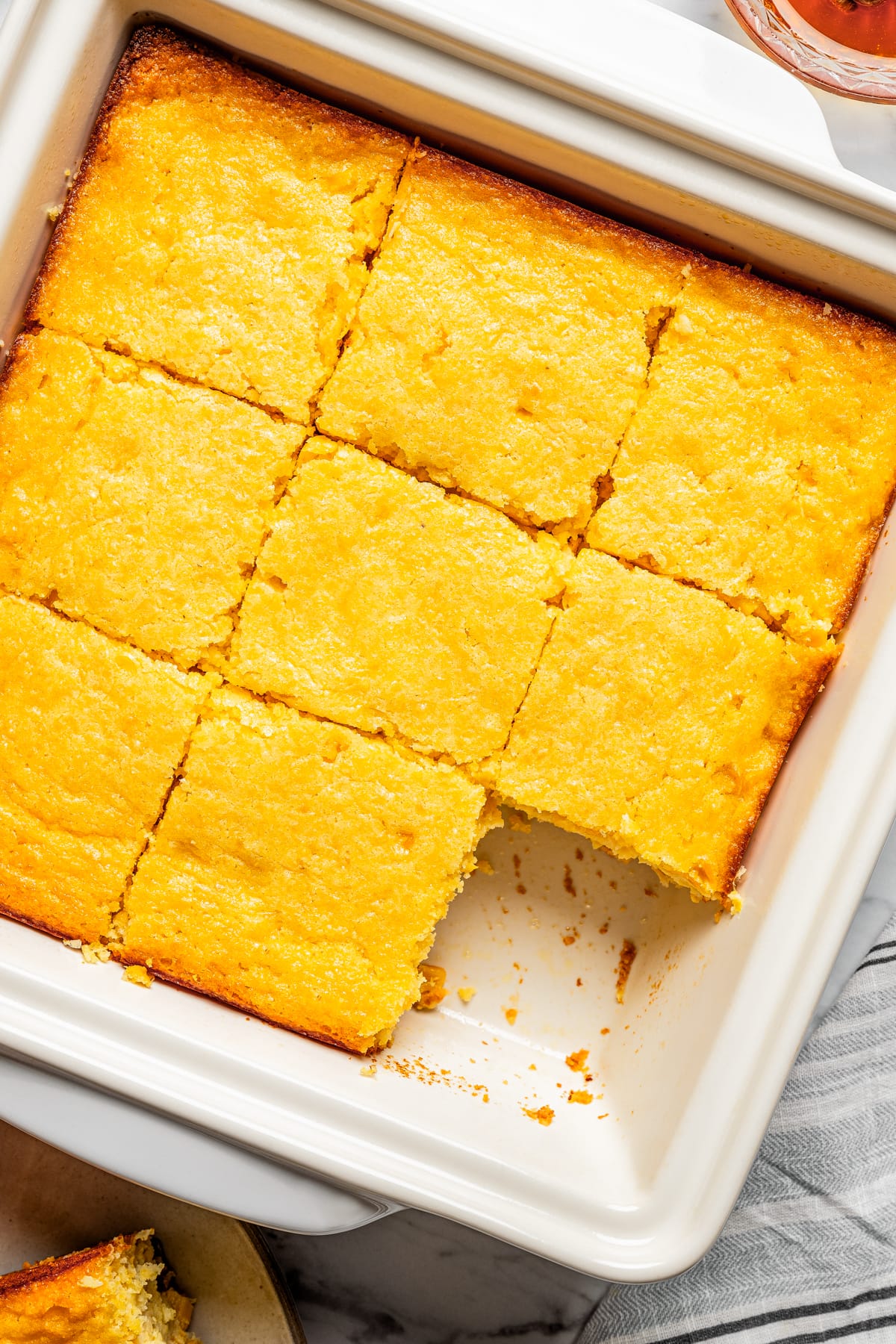 Sliced cornbread casserole in a baking pan.