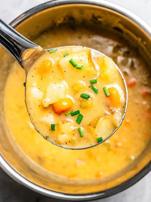 Holding a ladle full of Instant Pot potato soup up to the camera.
