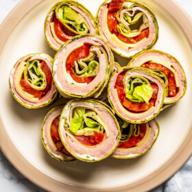 Overhead image of pinwheel sandwiches arranged on a serving plate.