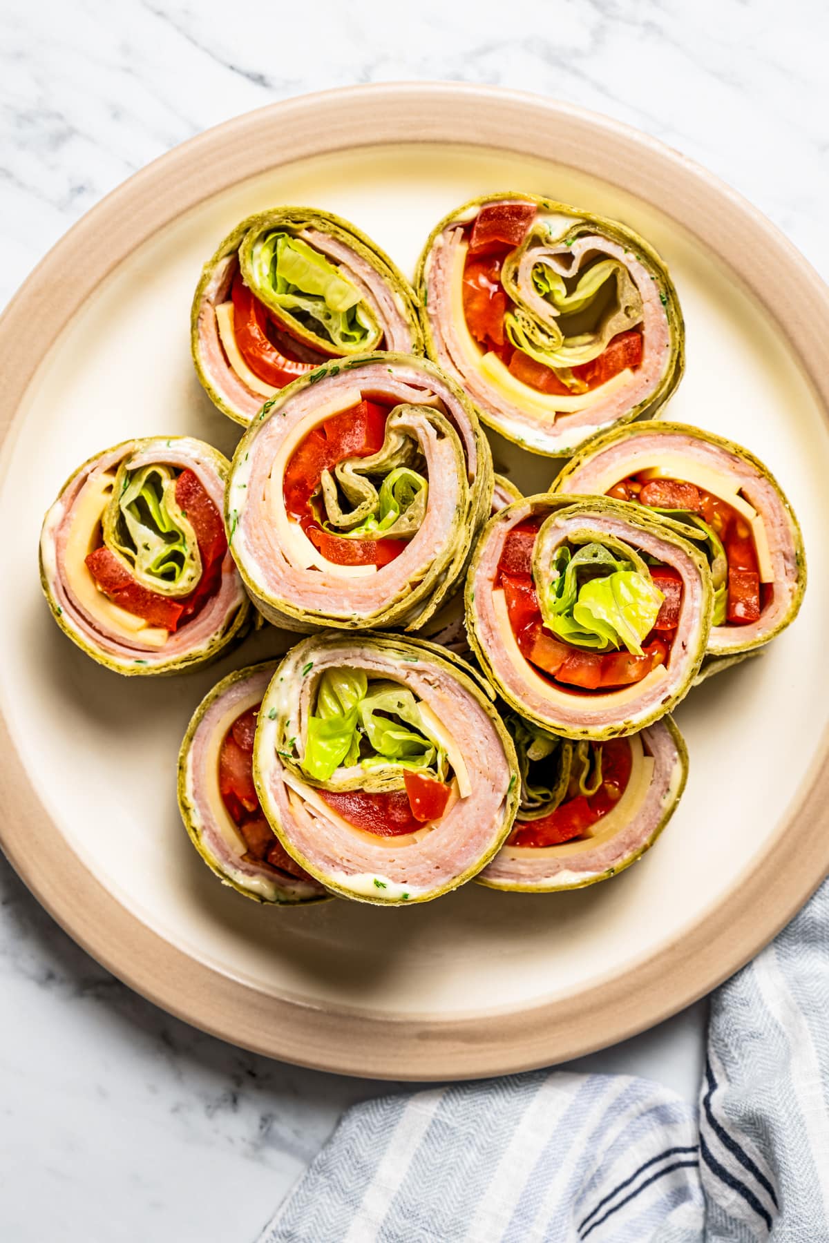 Overhead image of pinwheel sandwiches arranged on a serving plate.