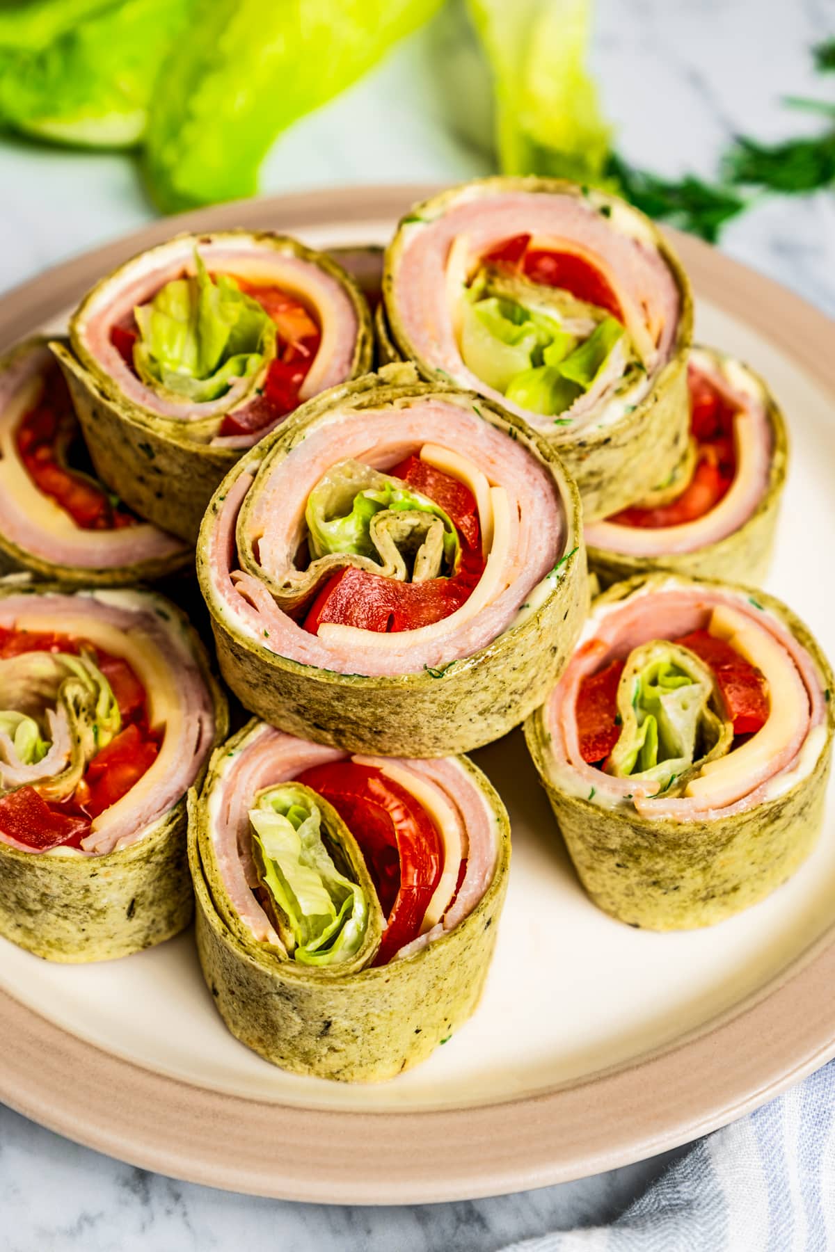 Pinwheel sandwiches stacked on a plate.