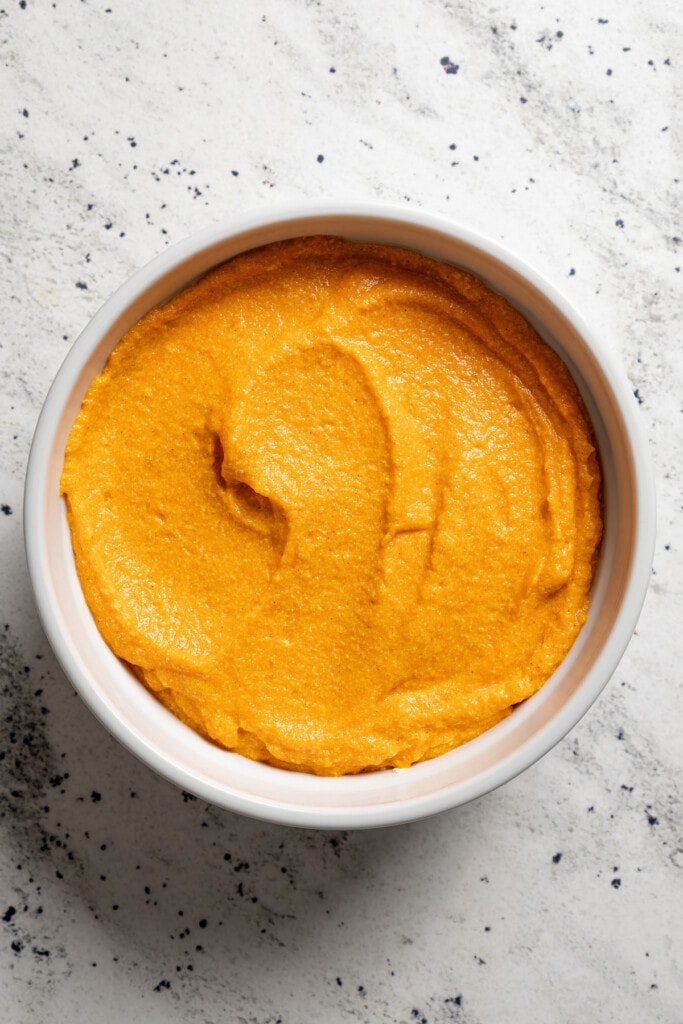 Batter for carrot souffle spread into a round baking dish.