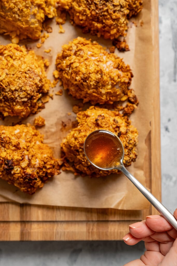 Drizzling hot honey over cornflake crusted chicken.