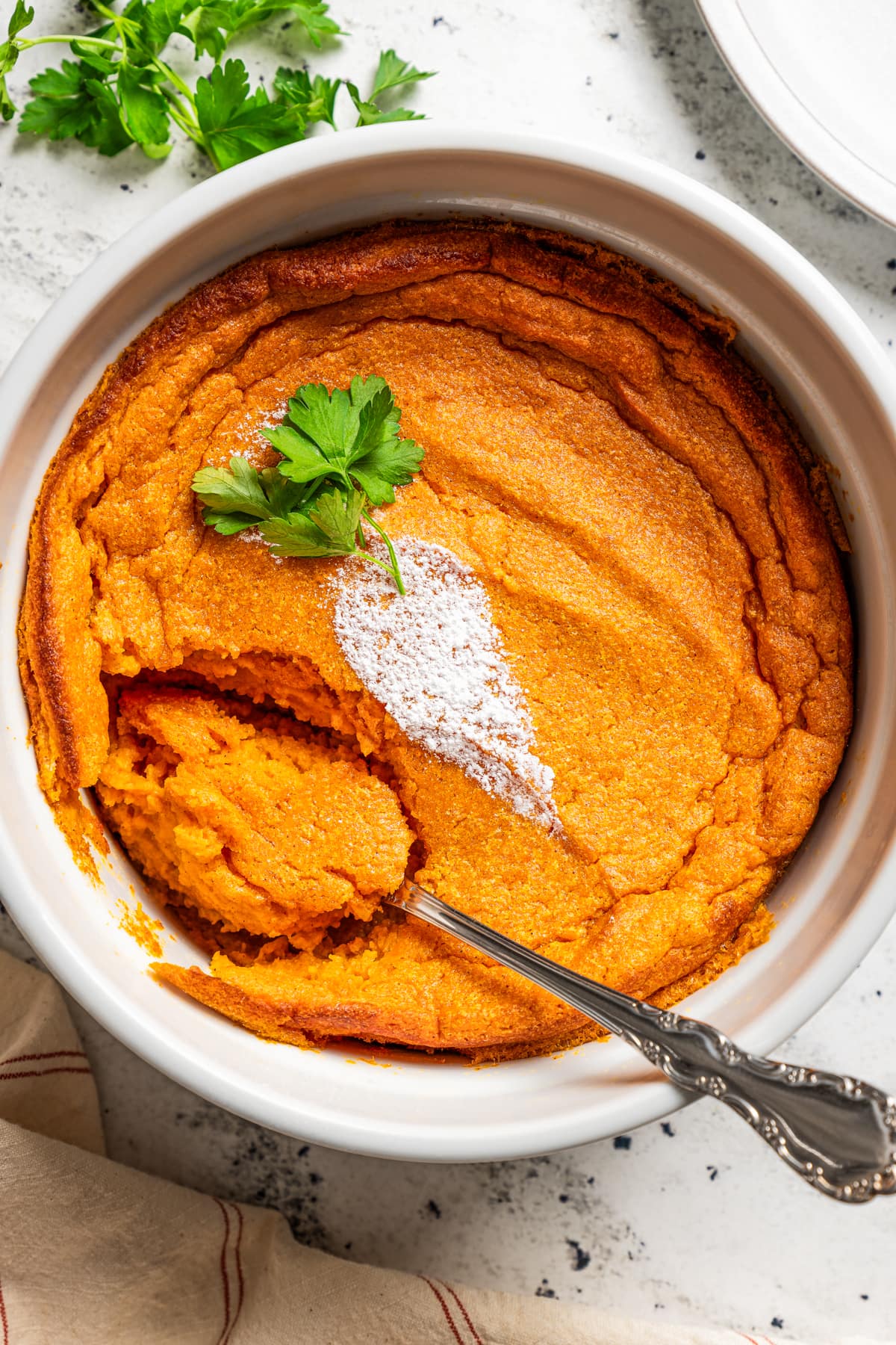Overhead image of carrot souffle with a spoon in it.