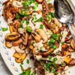 Closeup overhead image of a platter loaded with chopped steak and gravy.