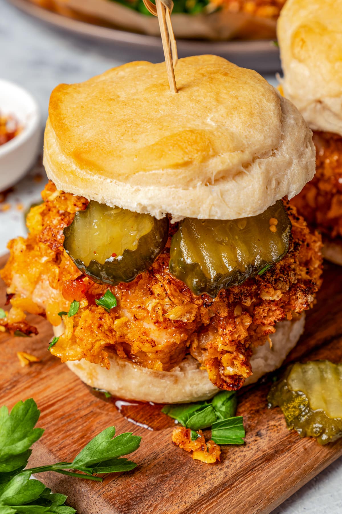 Hot honey chicken in a sandwich with pickle slices.