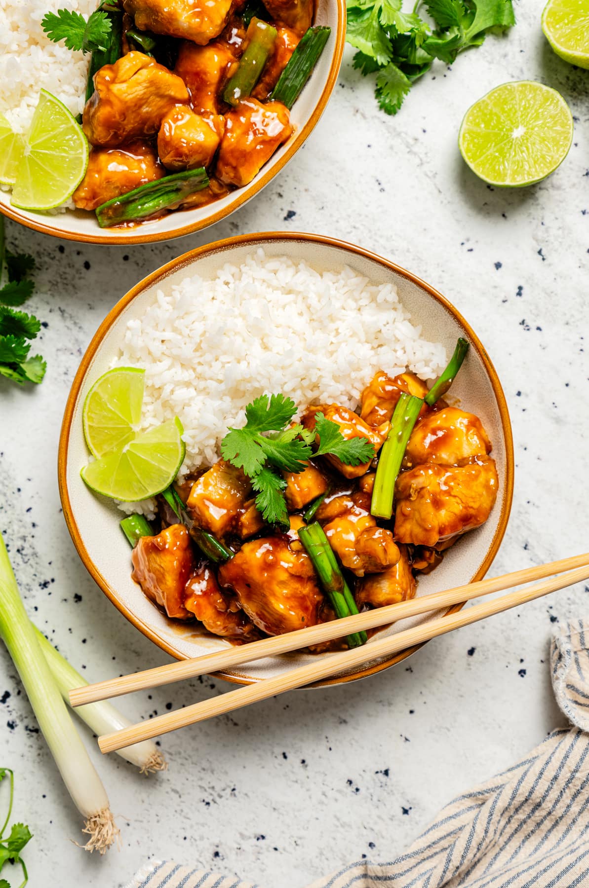 Overhead image of two bowls filled with rice and Mongolian chicken bites.