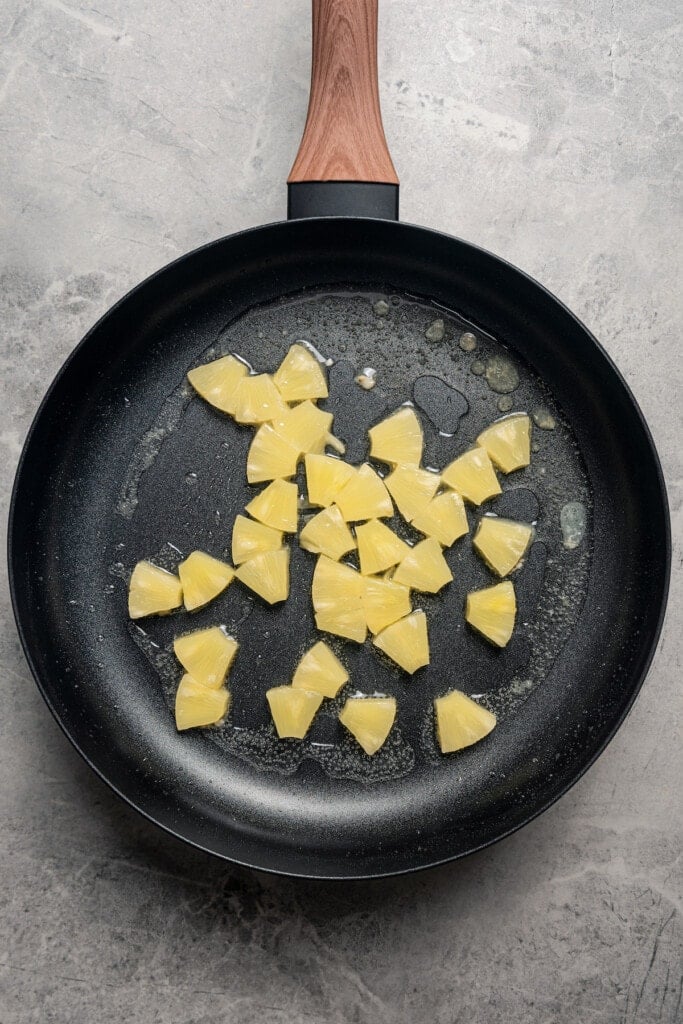 Frying pineapple in a pan.