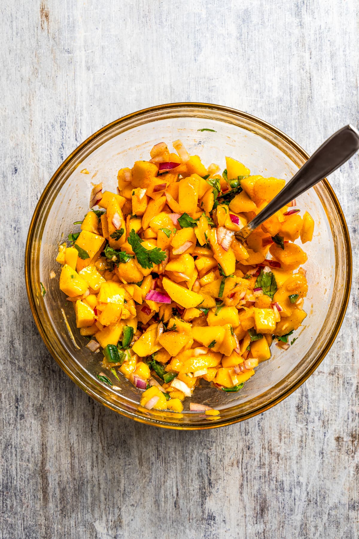 Mango salsa in a glass mixing bowl.