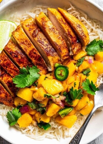 Sliced chicken breast served with mango salsa and jalapeno slices.