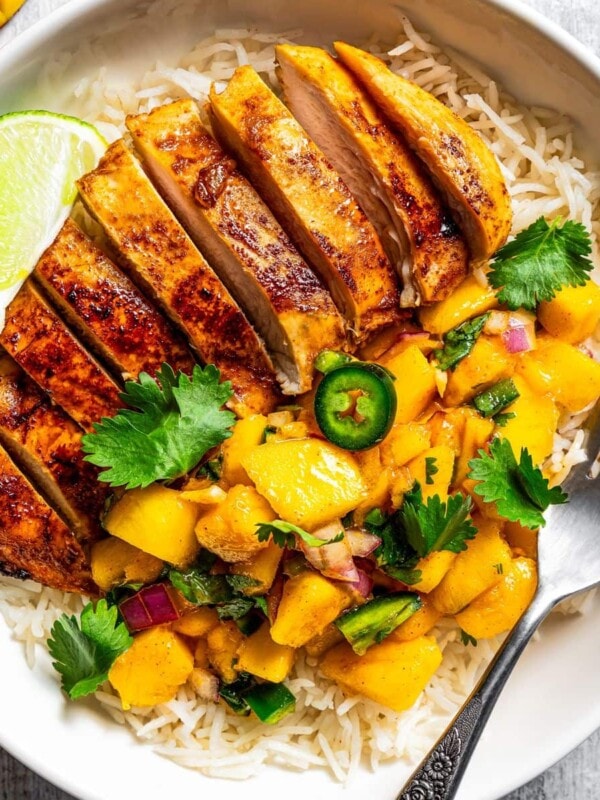 Sliced chicken breast served with mango salsa and jalapeno slices.