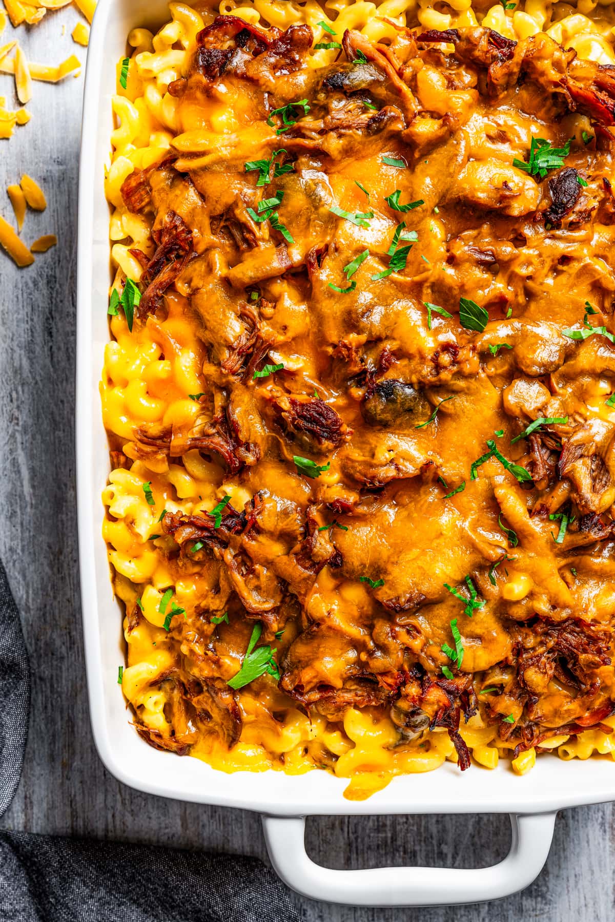 A white casserole dish full of pulled pork mac and cheese.
