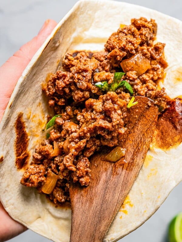 Stuffing a flour tortilla with taco meat.