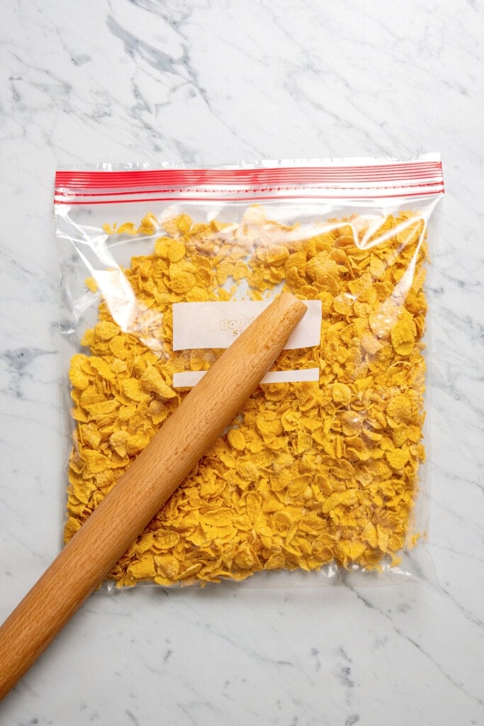 Crushing cornflakes in a bag.