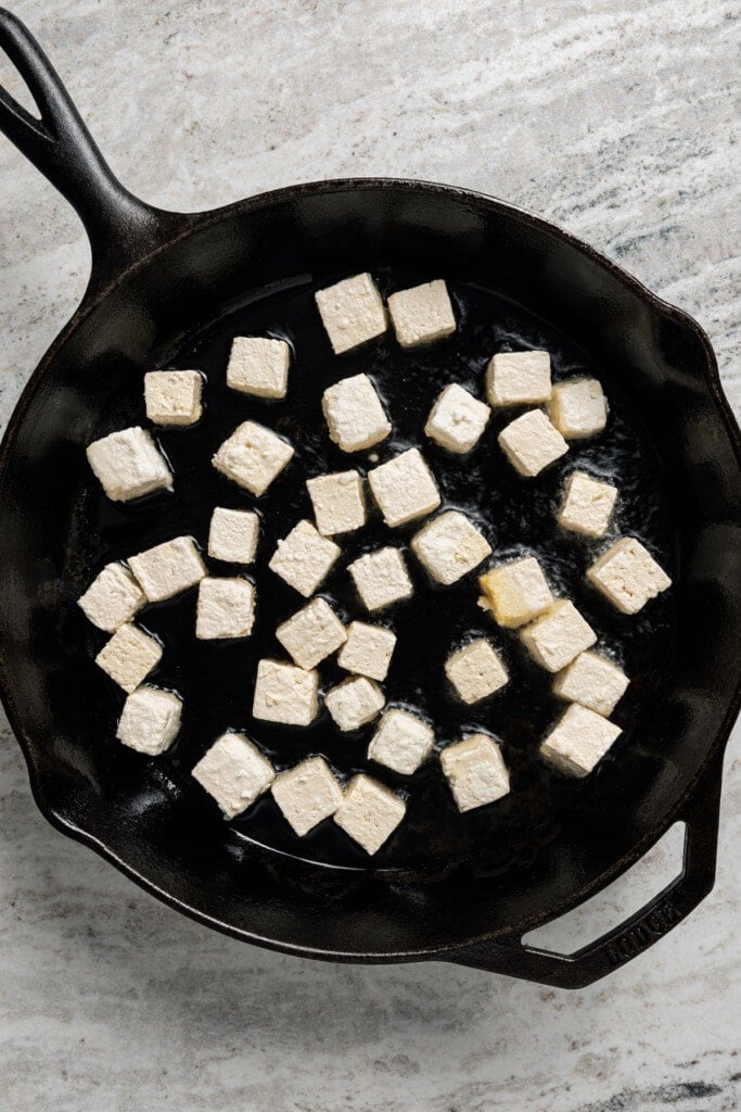 Frying tofu in a skillet.