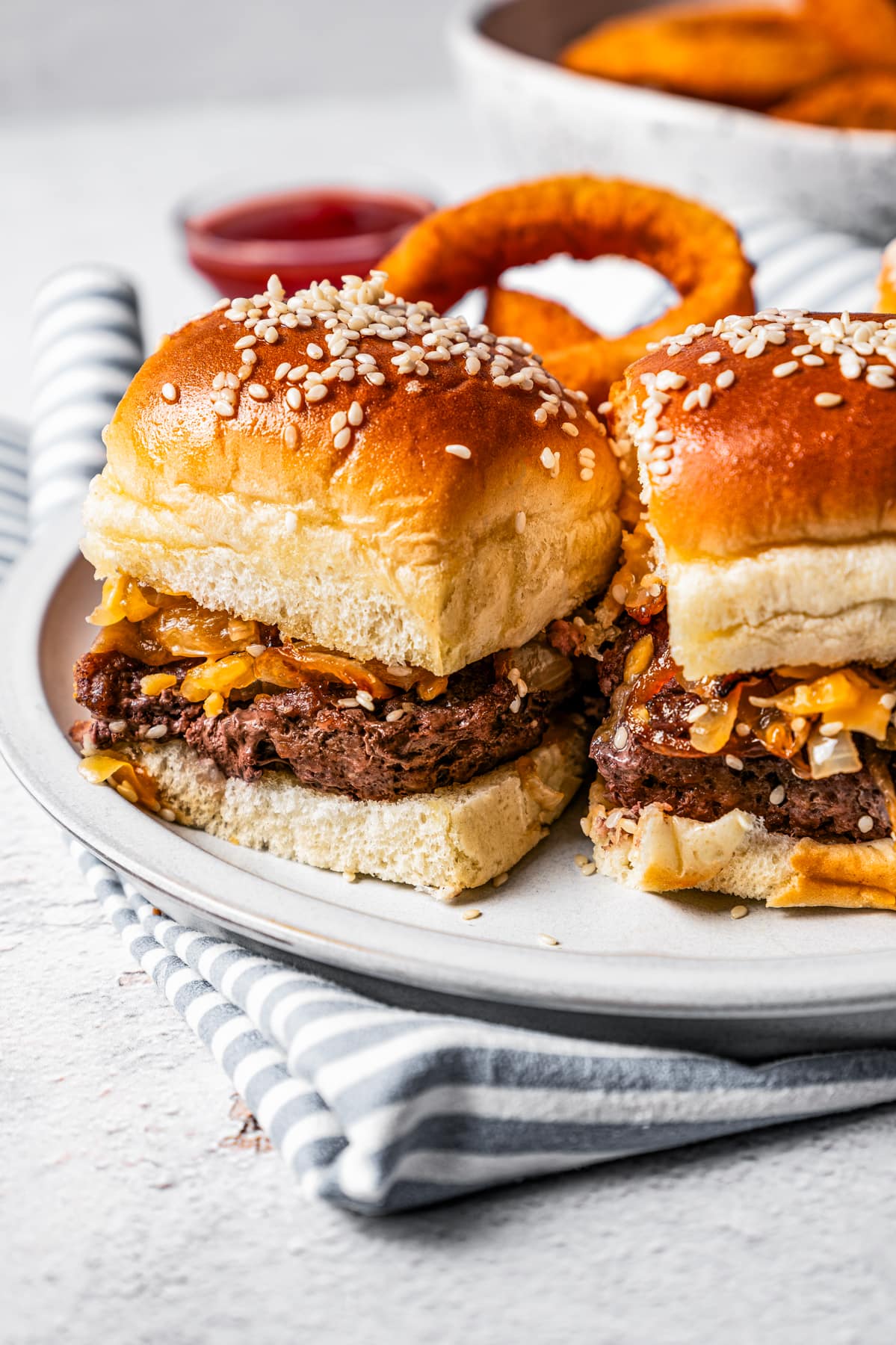 Sliders served on a plate that's set on top of a kitchen towel.