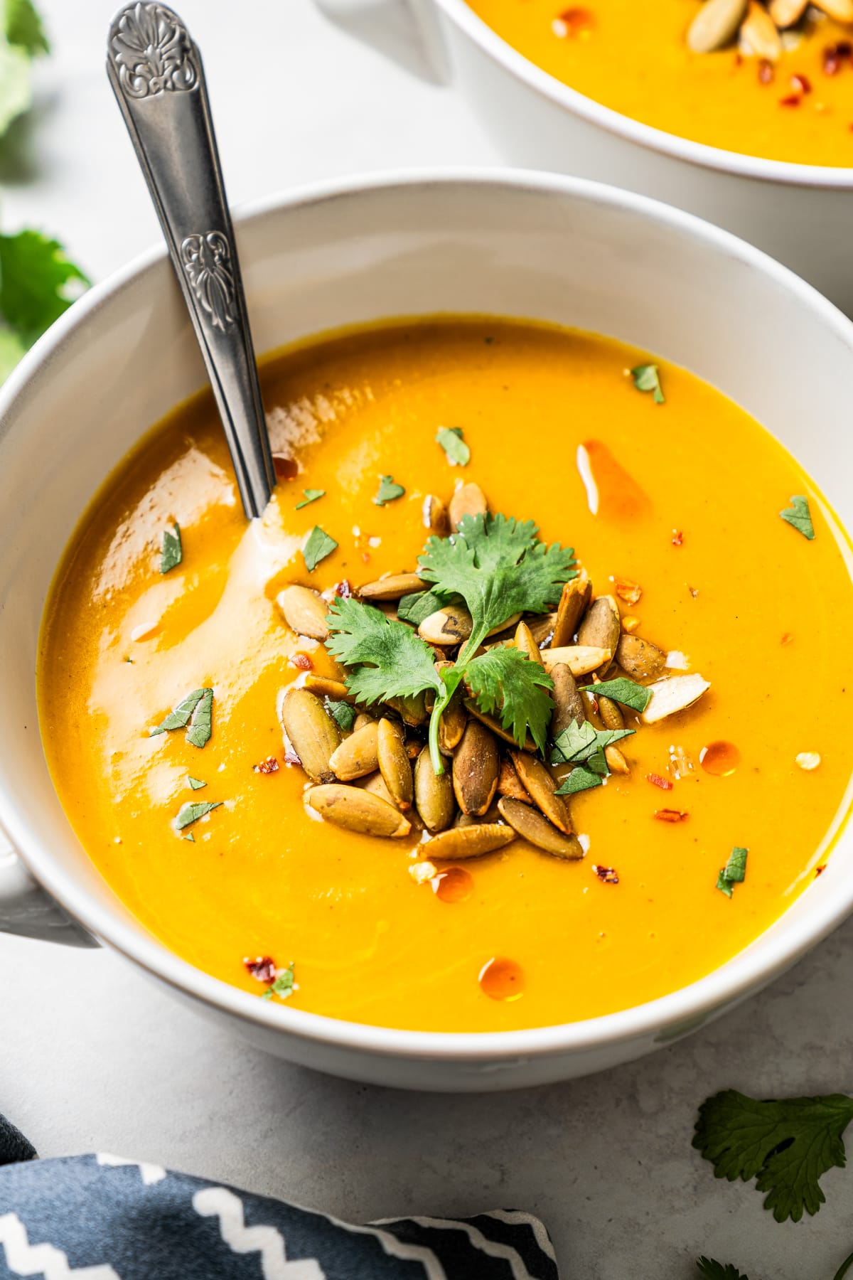 Overhead image of butternut squash soup in a bowl with a spoon.