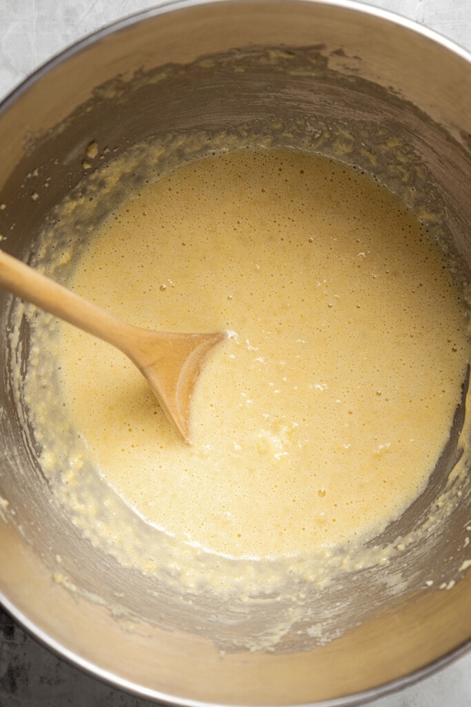 Mixing vanilla a sour cream into the wet ingredients for banana walnut muffin batter.