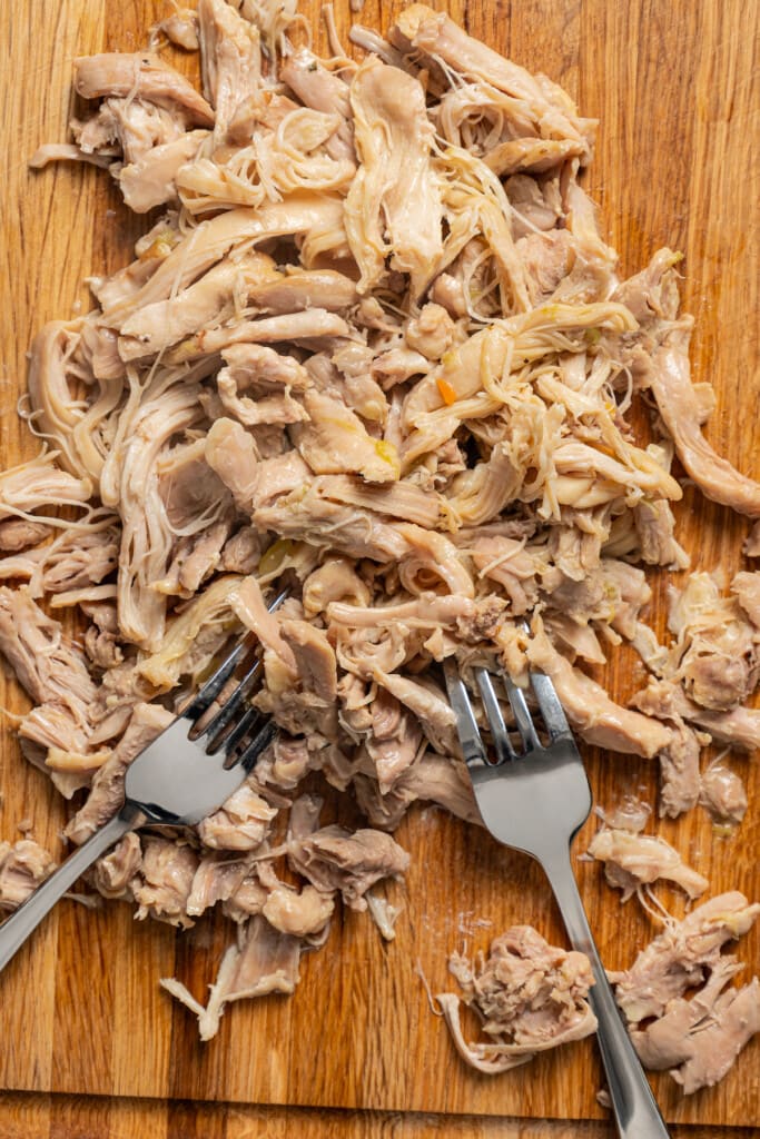 Shredding cooked chicken with 2 forks.