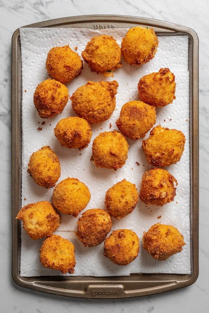 Potato croquettes on a baking sheet lined with paper towels.