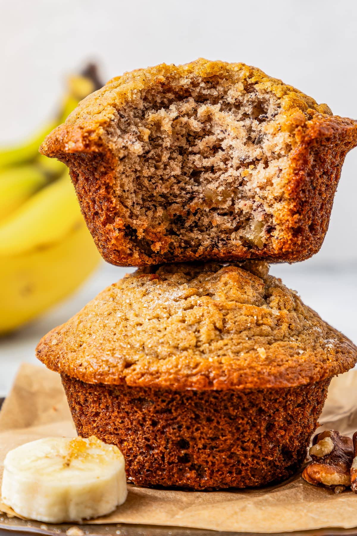 Two stacked up banana muffins, with the top muffin's texture exposed.