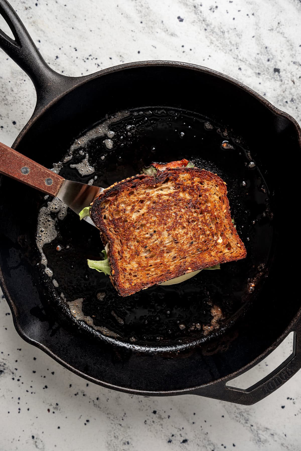 Grilling a bacon, egg, and cheese grilled cheese in a skillet.