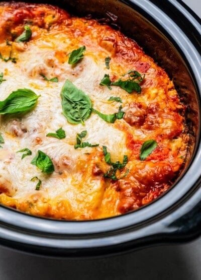 Cooked lasagna in a slow cooker insert.