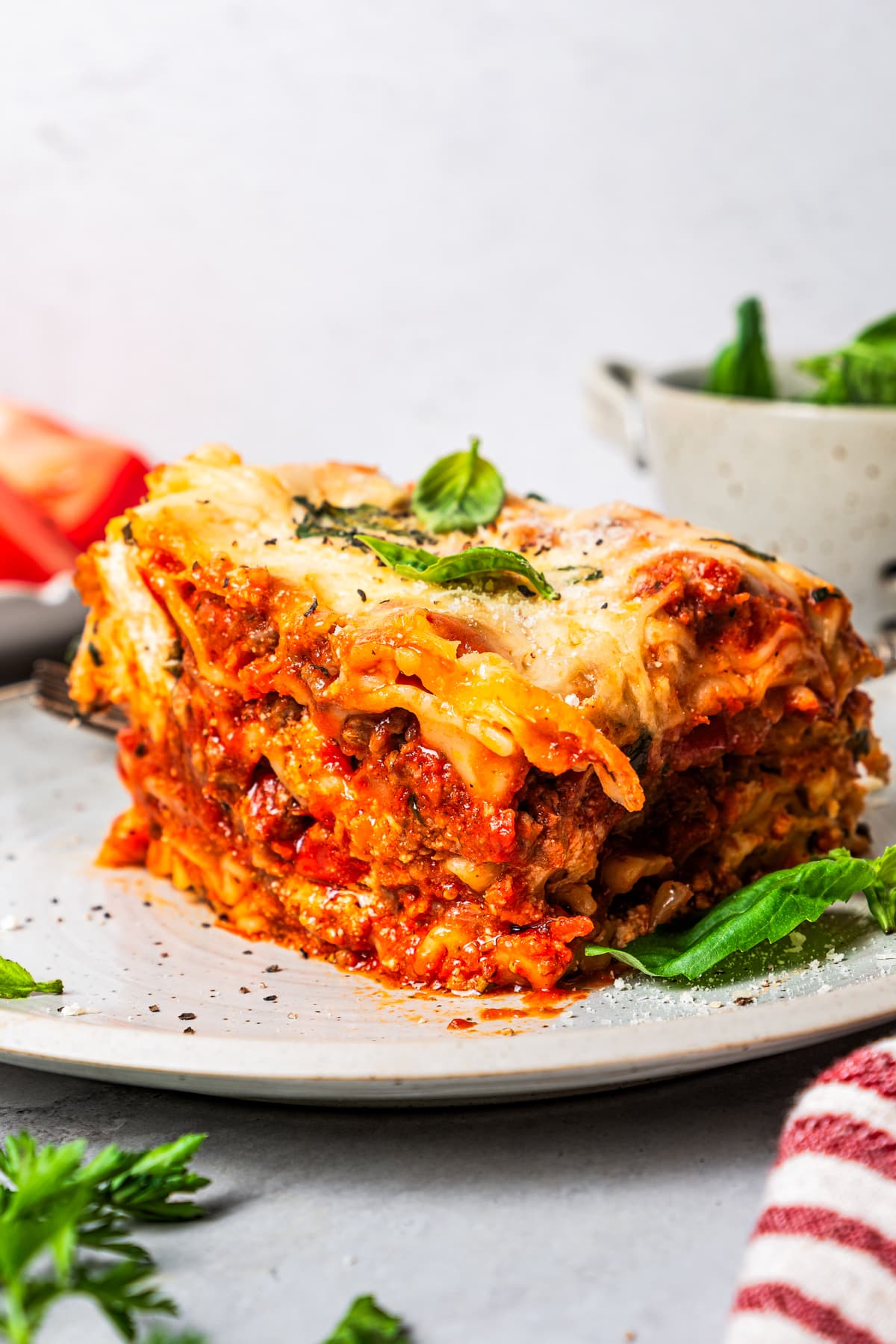 A cut piece of layers of pasta with meat sauce served on a plate.