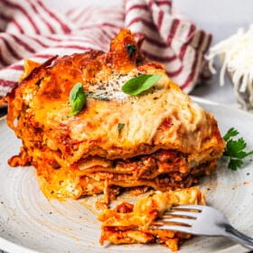 A fork cutting into a piece of lasagna.