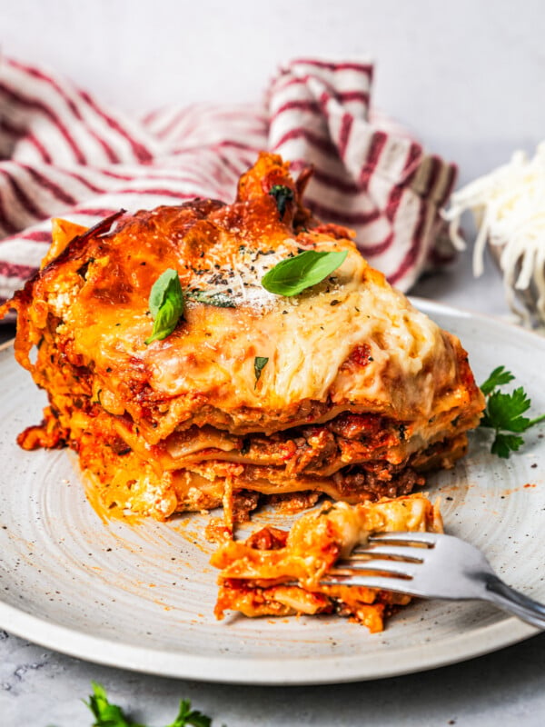 A fork cutting into a piece of lasagna.