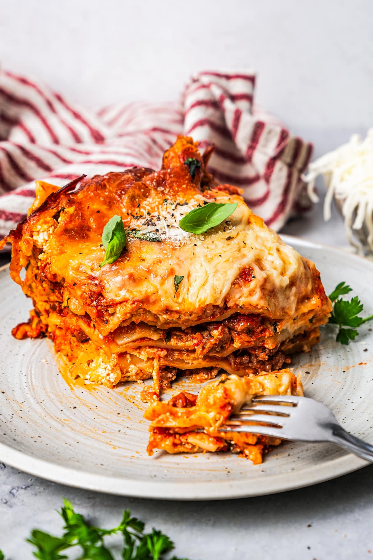 A fork cutting into a piece of lasagna.