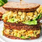 Piled-up curry chicken salad sandwich with chopped chicken, celery, apples, and more.