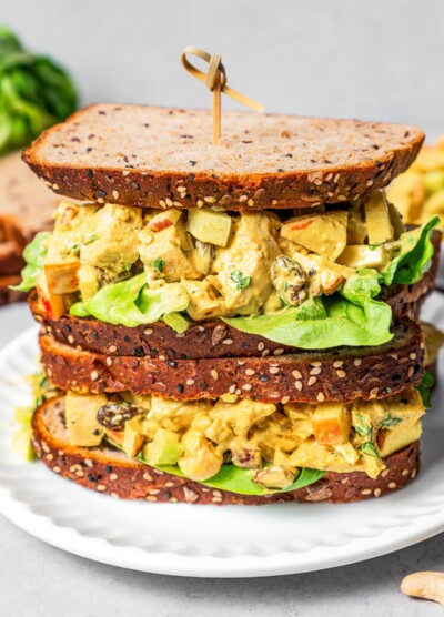 Piled-up curry chicken salad sandwich with chopped chicken, celery, apples, and more.