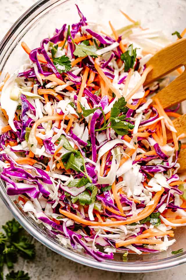 Cabbage slaw in a glass mixing bowl.