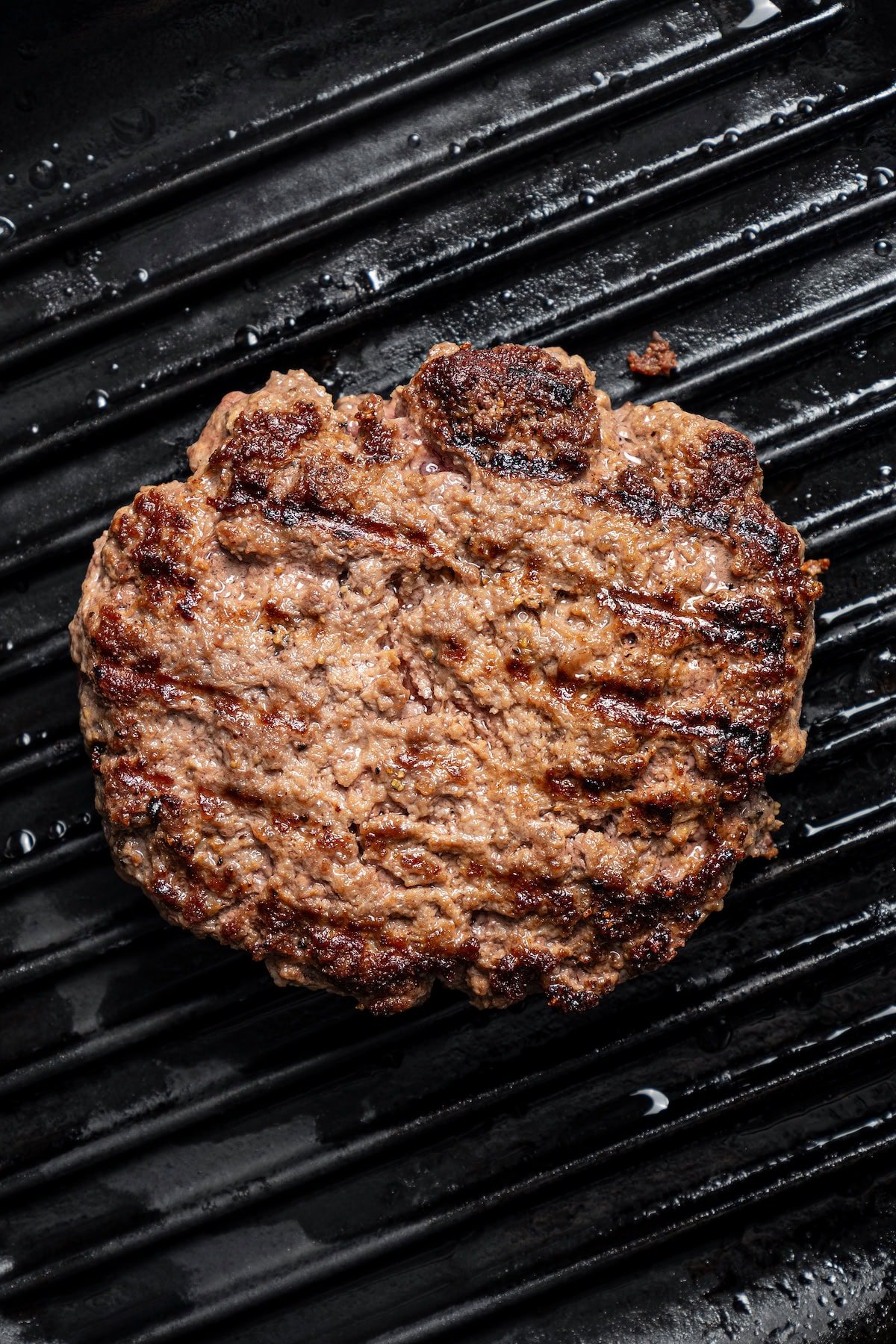 Close up of a grilled burger patty with grill lines.