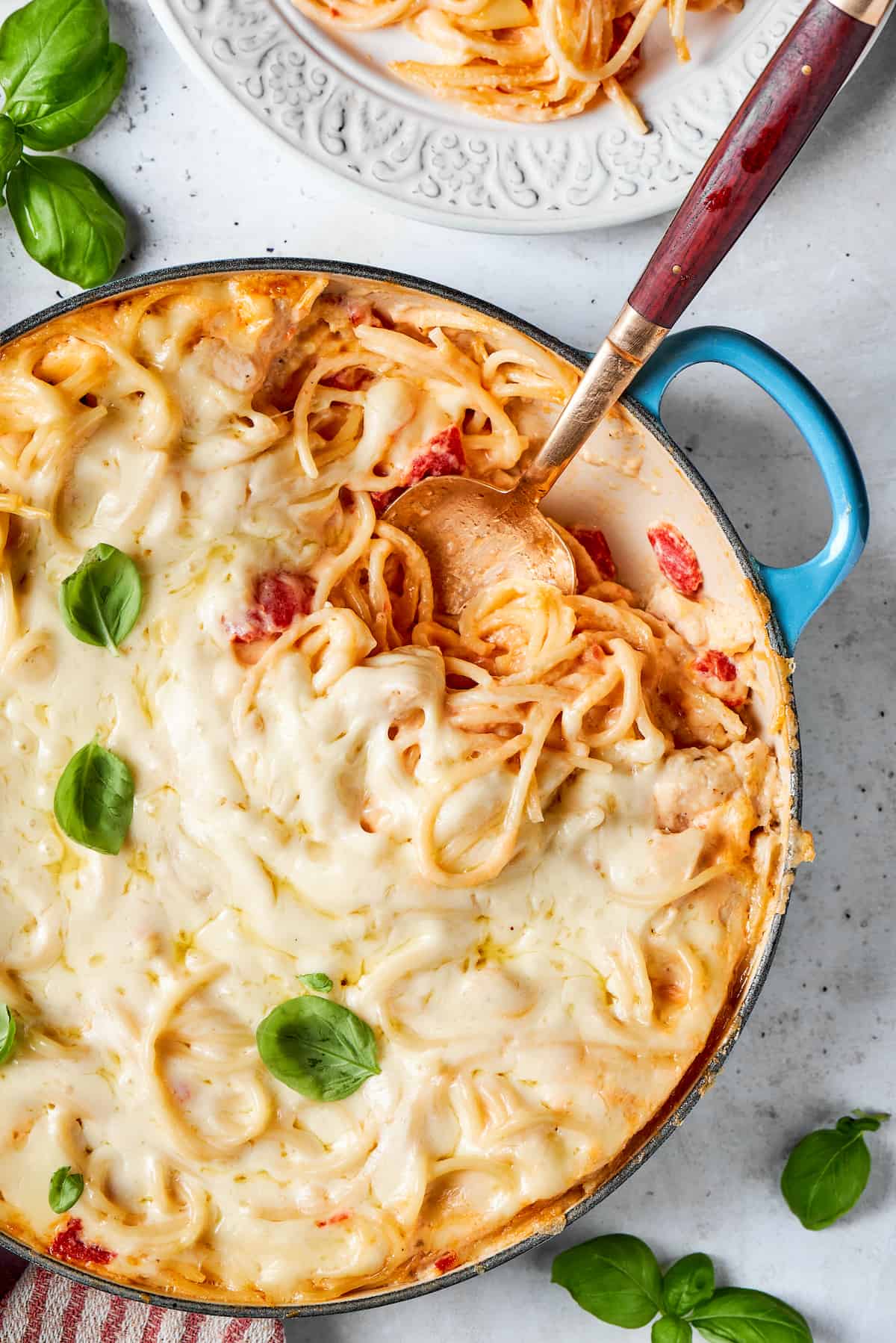 Spaghetti baked in a casserole dish with a layer of melted mozzarella cheese on top.