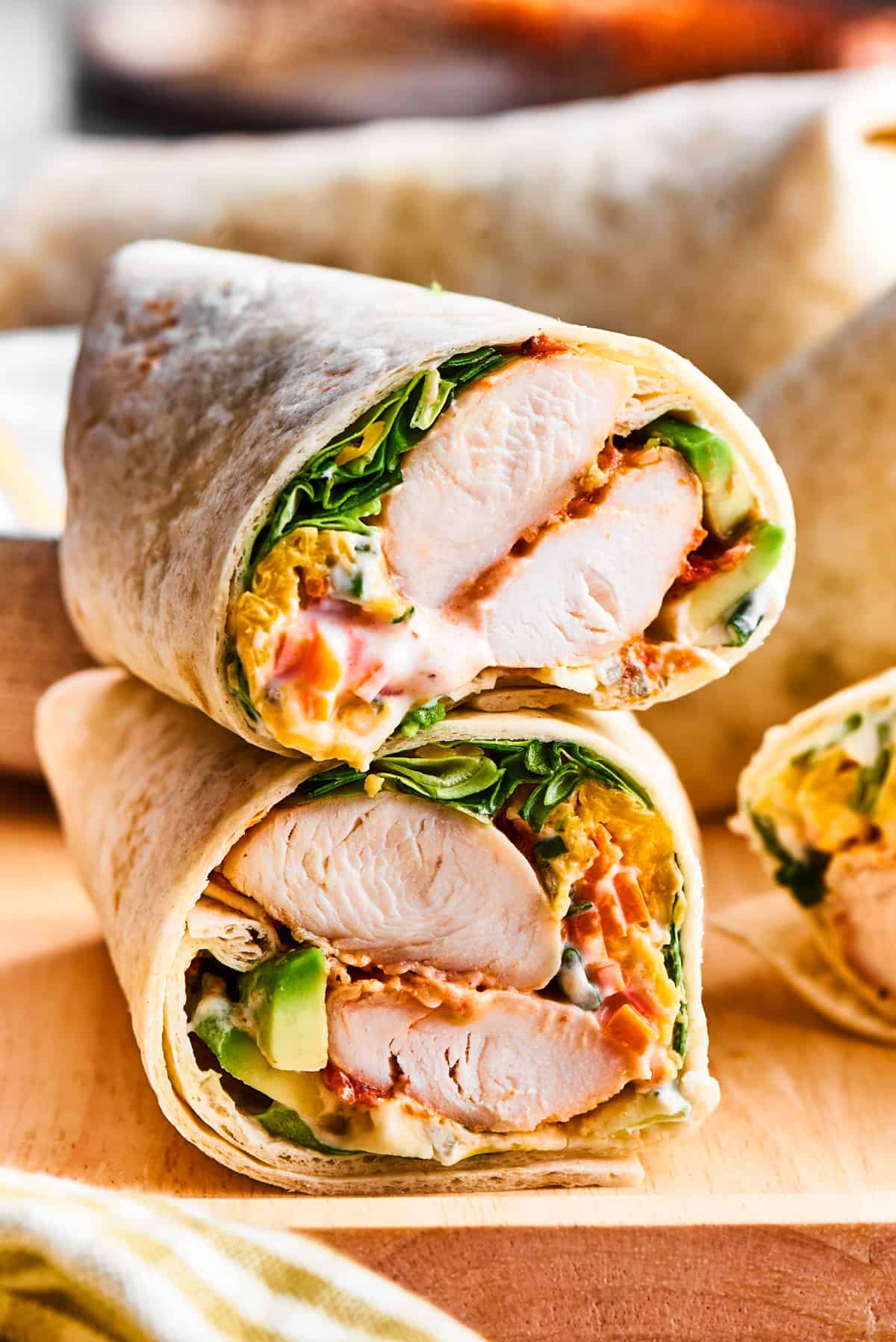 Two stacked wraps filled with cooked diced chicken and lettuce.
