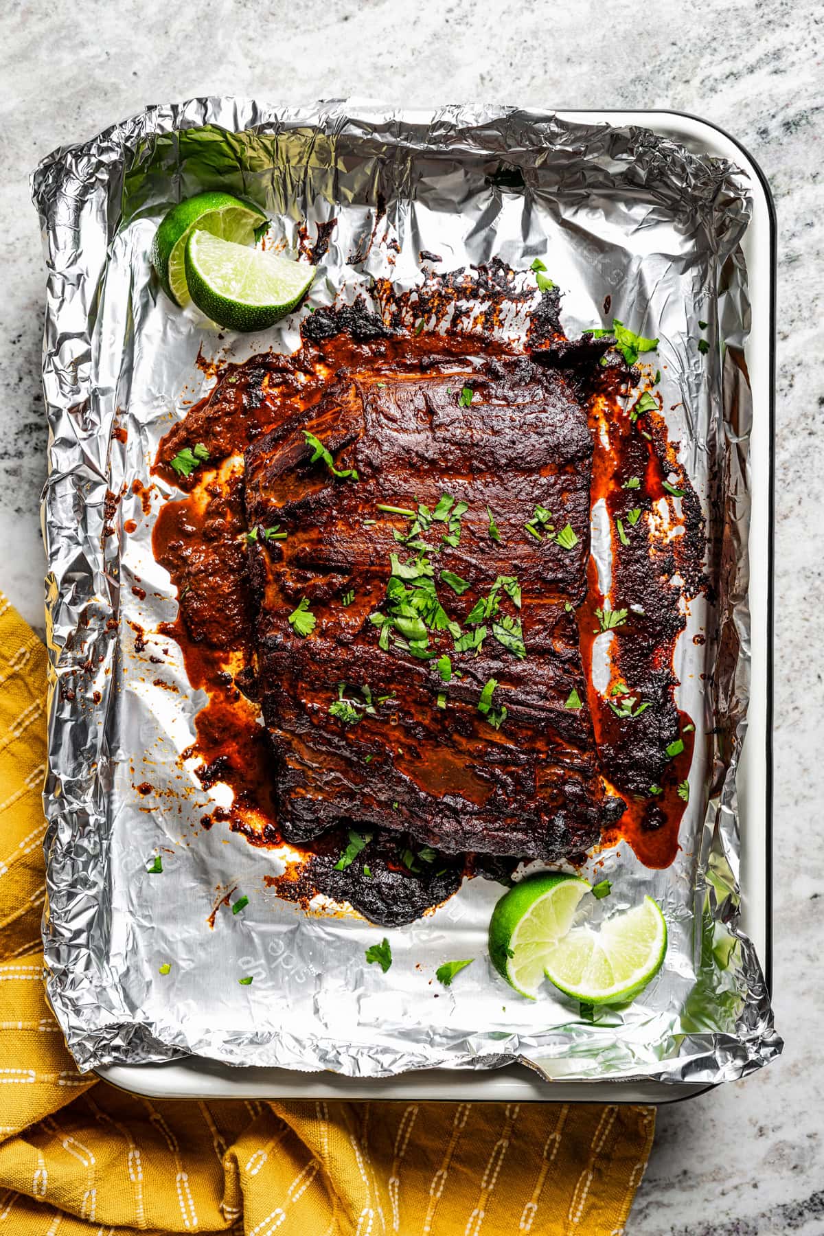 Overhead view of a steak on a foil-lined baking sheet.
