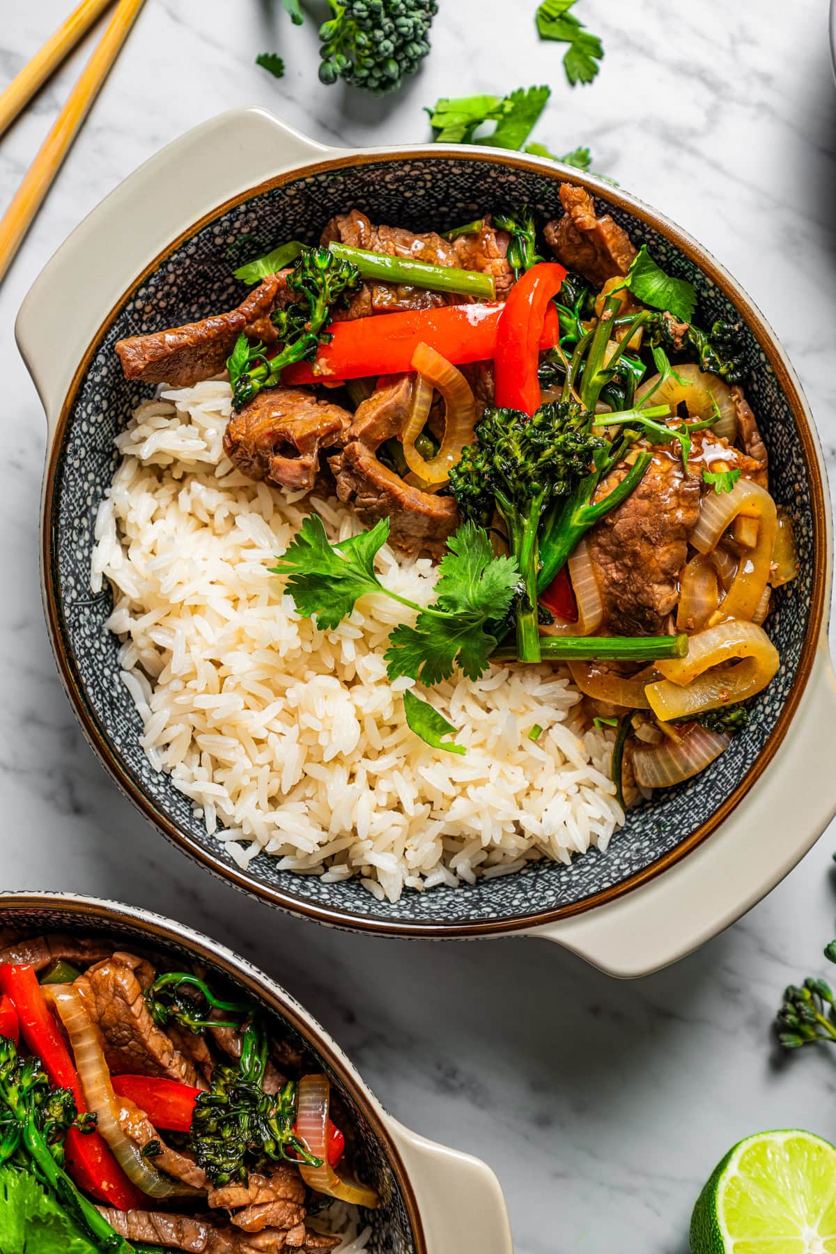 Hunan beef served over rice in a bowl.