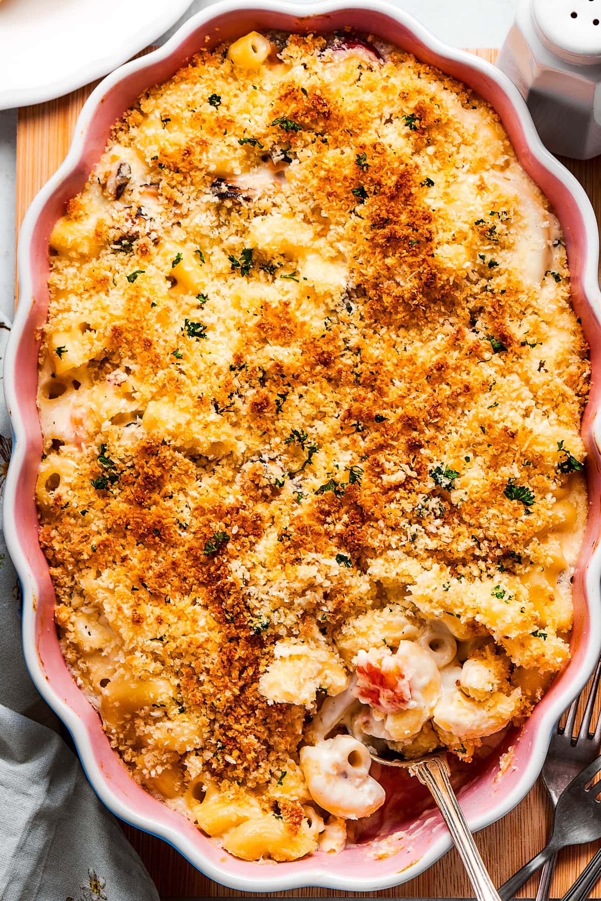 Seafood mac and cheese in a baking dish topped with toasted breadcrumbs.