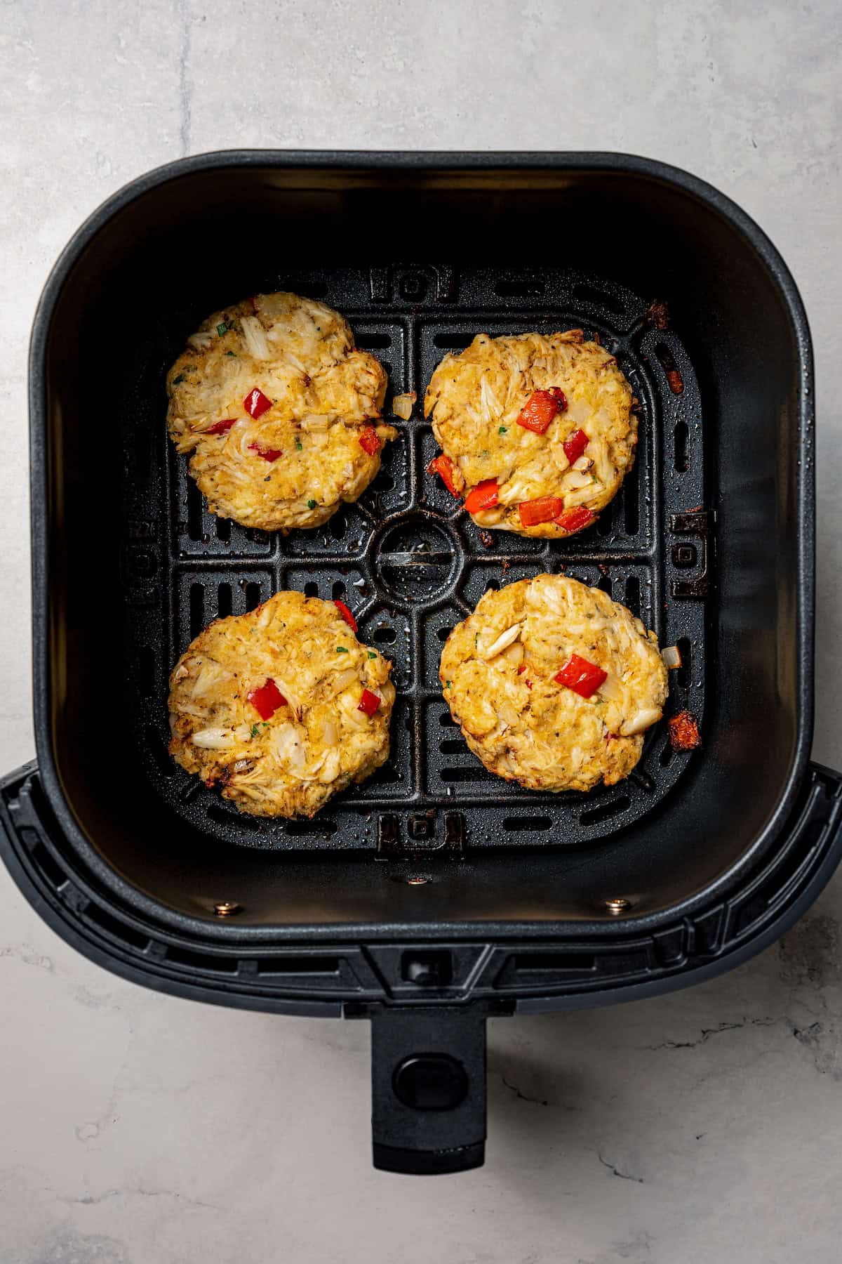 Cooked crab cakes inside the air fryer.