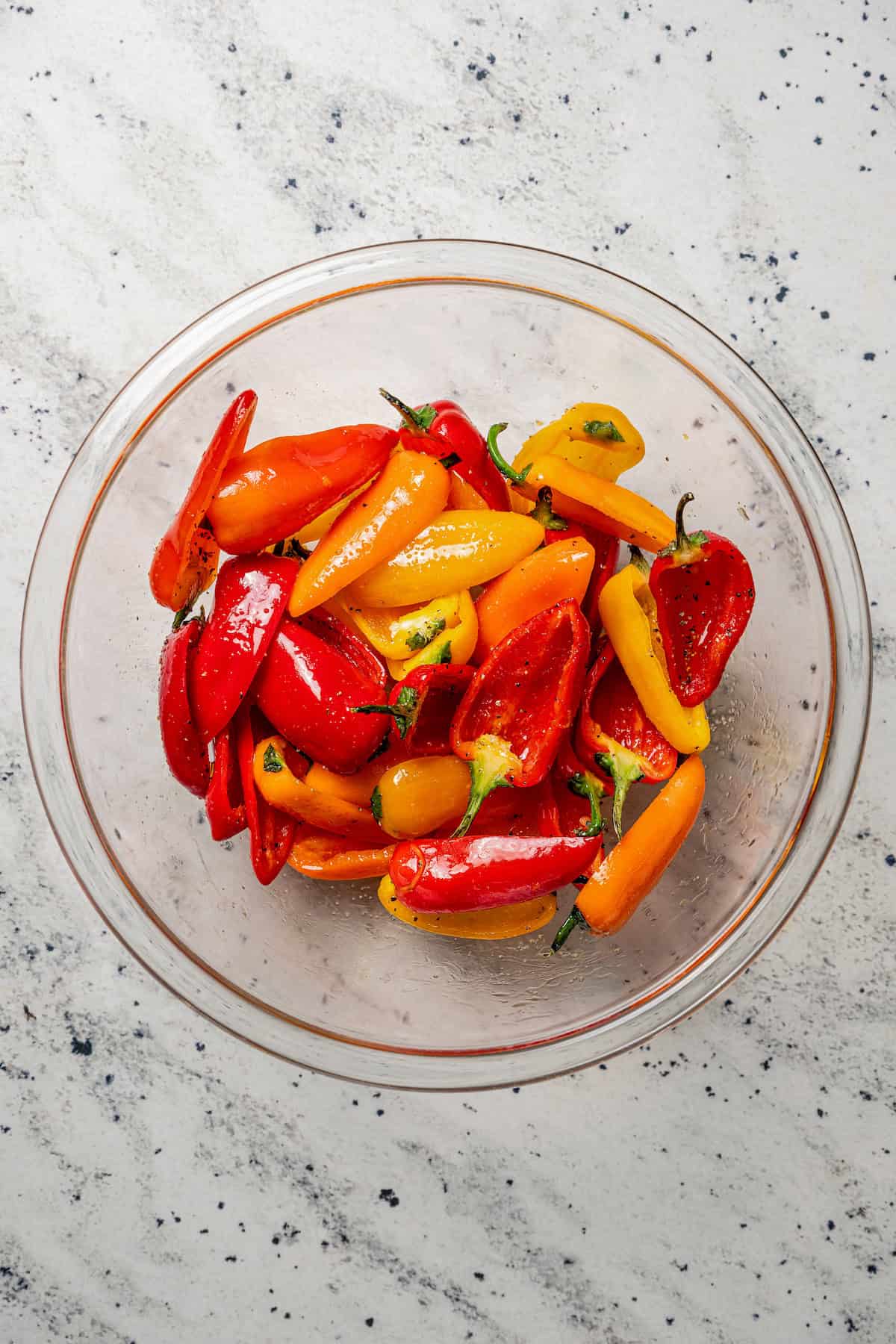 Seasoned mini bell pepper halves in a glass bowl.