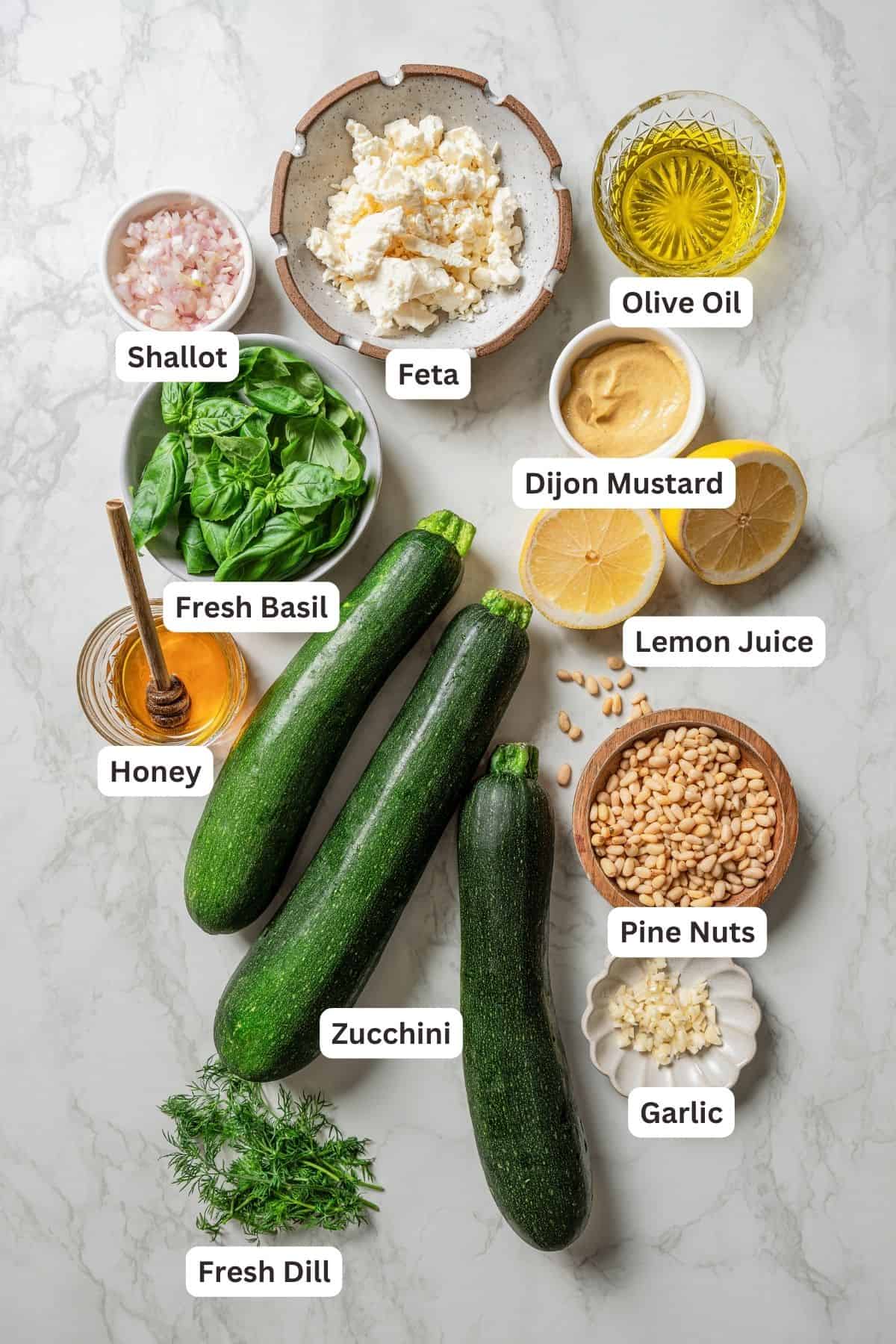 Ingredients for zucchini salad and dressing with text labels overlaying each ingredient.