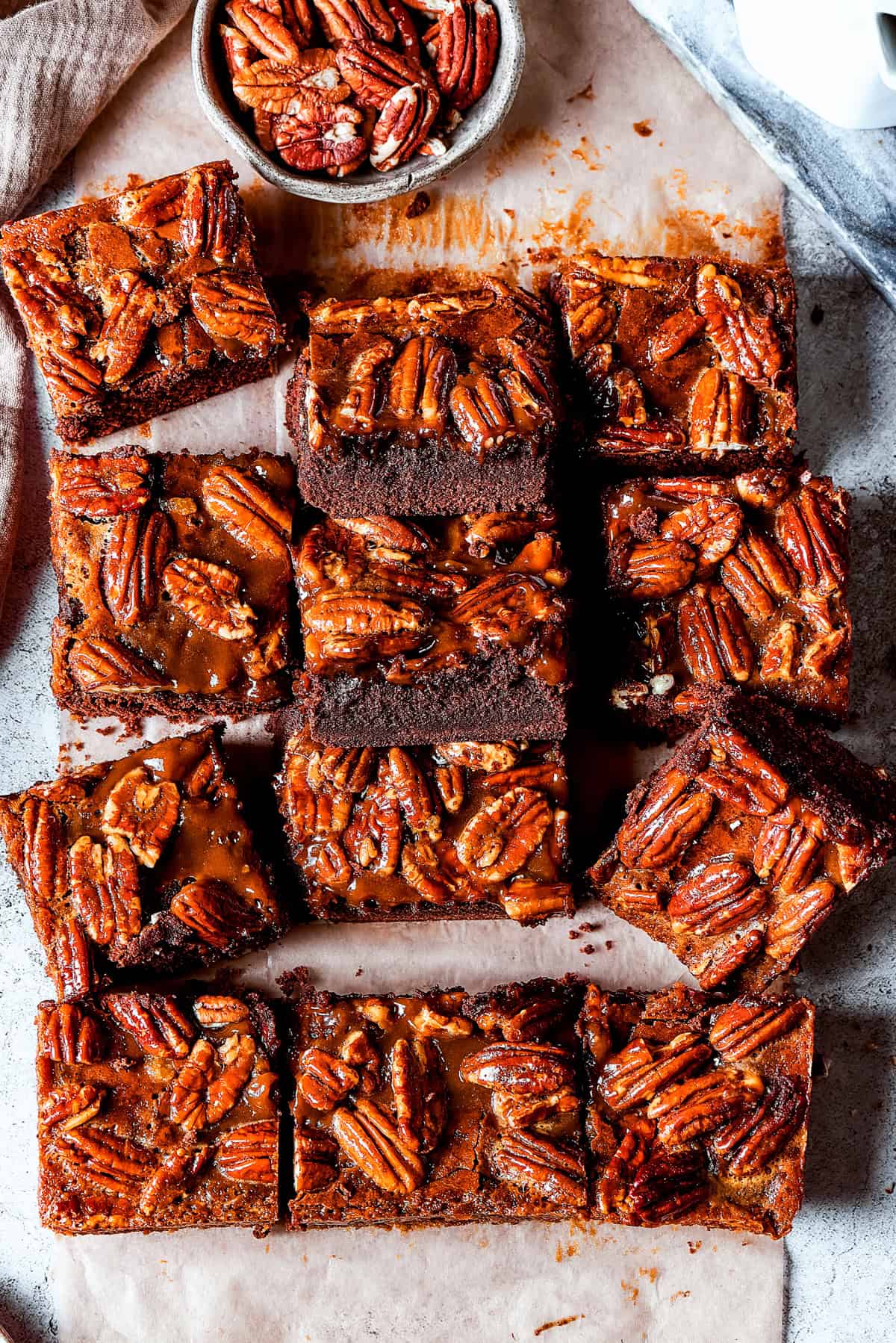 An overhead image of several brownies topped with pecans.