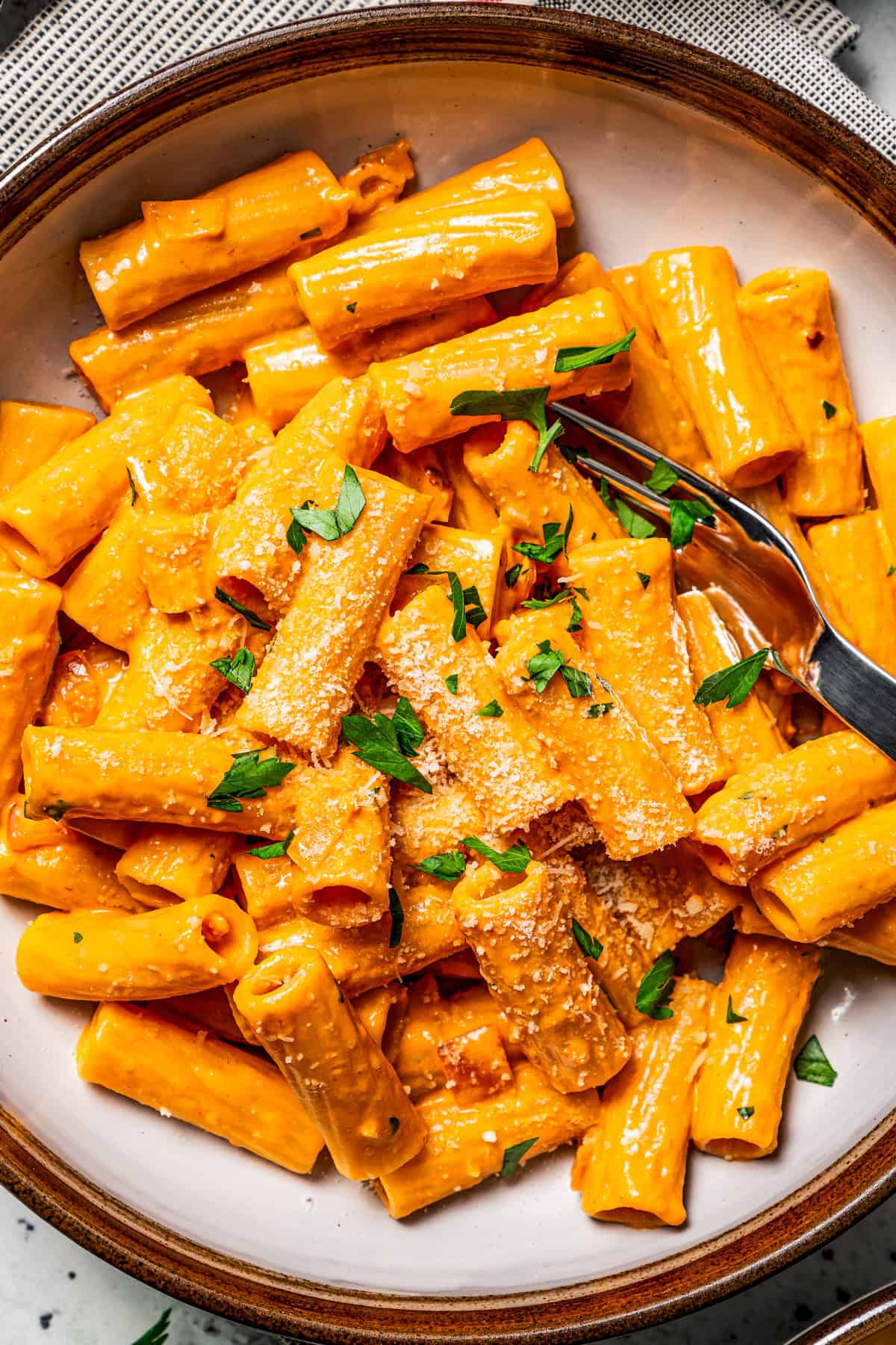 Rigatoni pasta served in a bowl with a fork.
