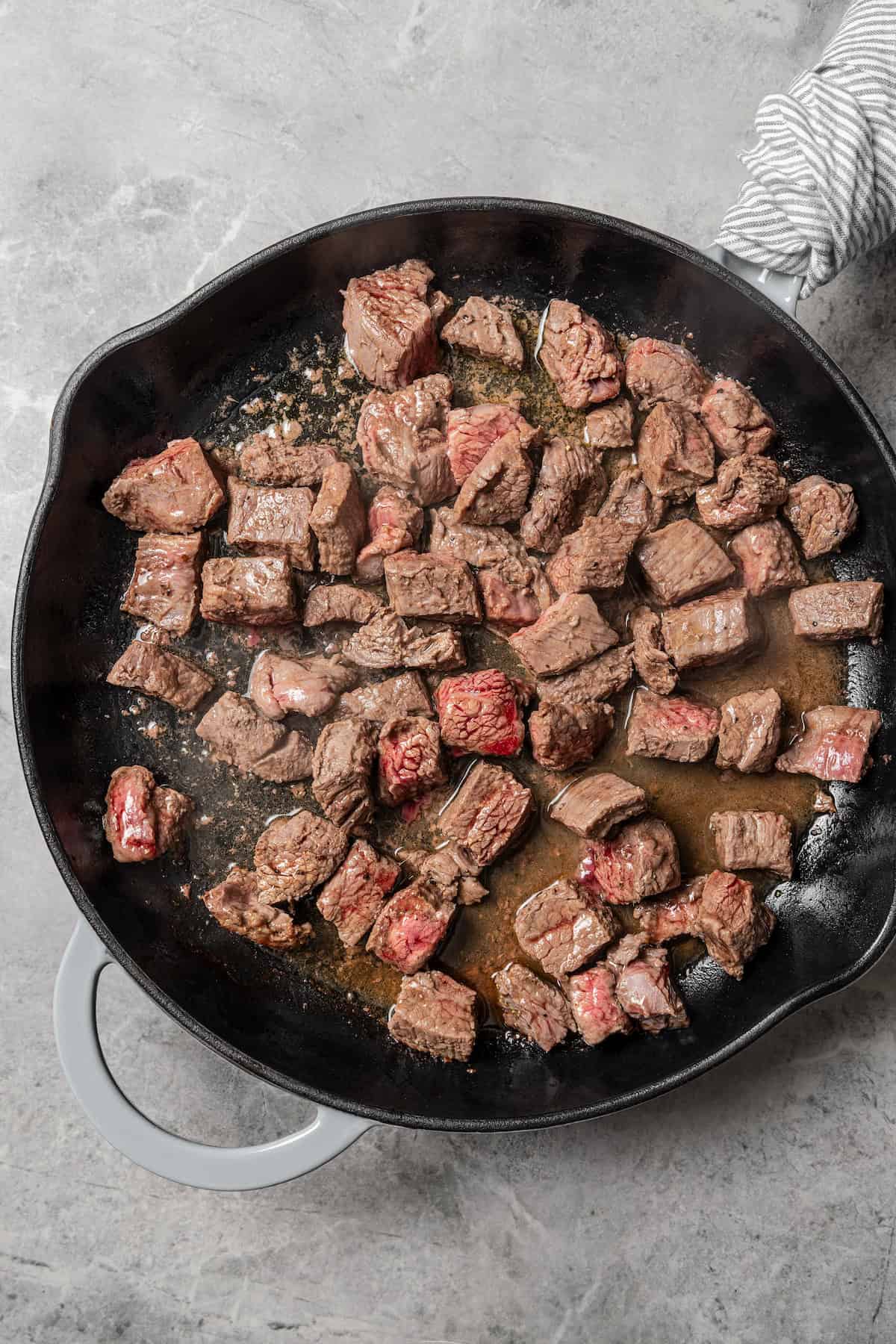 Cubed beef browning in a skillet.