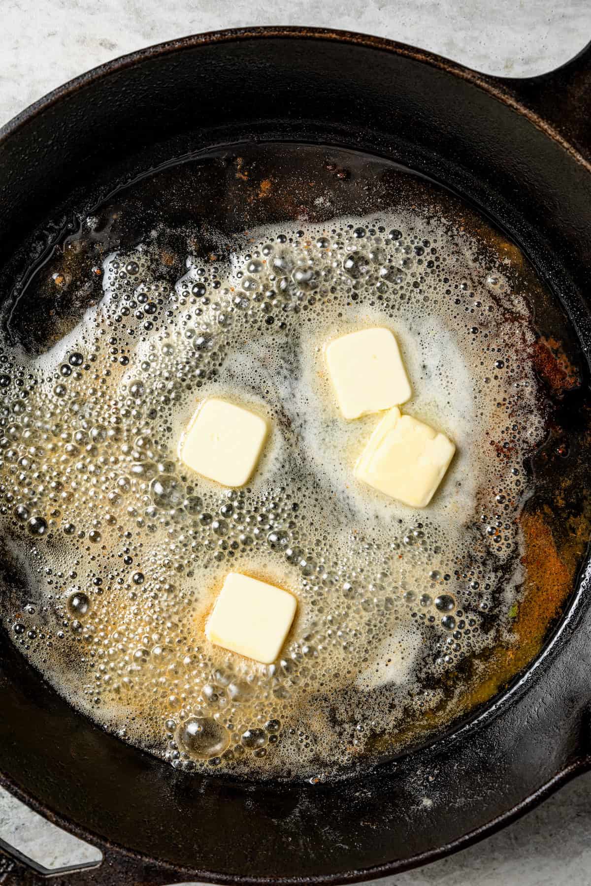 Butter melting in a cast iron skillet.